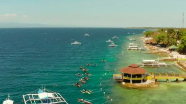 Turistler turkuaz su ve hava manzaralı mercan resiflerinde şnorkelle yüzerler. Moalboal, Filipinler. İnsanlar mercan resifleri arasındaki şeffaf denizde yüzerler. Yaz ve seyahat tatil konsepti.