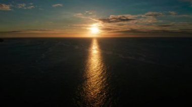 Deniz yüzeyinde gün batımı dalgalarla, hava manzaralı. Su yüzeyine yansıyan güneş. Okyanusun üzerinde gün batımı. Deniz manzarası, yaz ve tatil konsepti