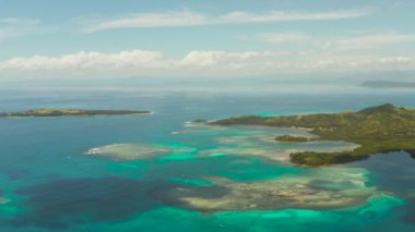 Adalar bir mercan adası ve mavi su manzaralı bir mercan resifiyle çevrilidir. Bucas grande, Filipinler. Yaz ve seyahat tatil konsepti.