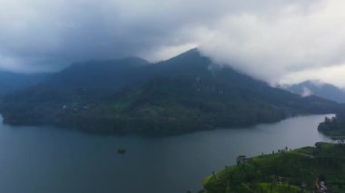 Dağların arasındaki göl manzarası ve çay bahçeli yeşil tepeler. Maskeliya, Maussakelle rezervi, Sri Lanka.