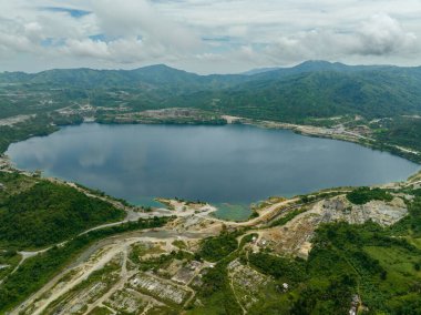 An artificial lake in an abandoned mining quarry. Quarry pond with turquoise water. Sipalay, Negros, Philippines. clipart