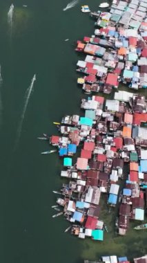 Borneo 'daki köyün en iyi manzarası. Suyun üstünde duran evler var. Borneo, Semporna. Sabah, Malezya. Dikey video.