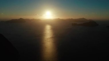 Gün batımında El Nido 'daki tropik hava aracı körfezi. Denizin üzerinde gün batımı. Güneş doğarken tropikal adalarla kaplı deniz manzarası. Yaz ve seyahat tatil konsepti Palawan, Filipinler