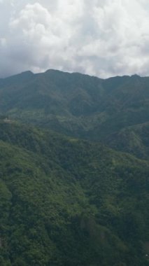 Aerial view of mountains and hills with green vegetation and trees in the tropics. Negros, Philippines