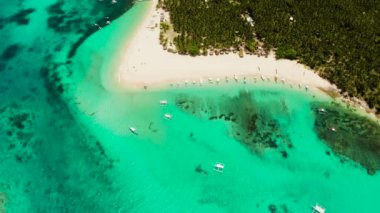 Tropikal bir adada turistler ve teknelerle dolu bir plaj, berrak mavi su. Daco Adası, Filipinler. Yaz ve seyahat tatil konsepti