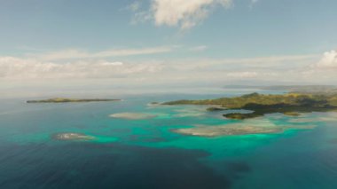 Mavi suyla mercan adası ve güneşli bir günde okyanusta tropik bir ada. Bucas grande, Filipinler. Yaz ve seyahat tatil konsepti.
