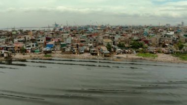 Liman yakınında çöp ile kirlenmiş bir nehrin kıyısında Manila Gecekondu, havadan görünümü.