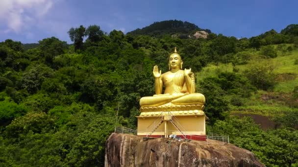Luchtfoto Van Standbeeld Van Een Zittende Gouden Boeddha Een Rots — Stockvideo