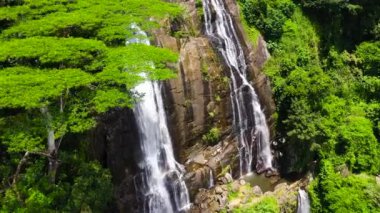 A beautiful Hunnasgiriya waterfall among the rainforest and vegetation. Hunas Falls, Sri Lanka.