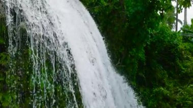 Waterfall in a tropical forest. Aerial view of Lusno Falls in slow motion. Cebu, Philippines.