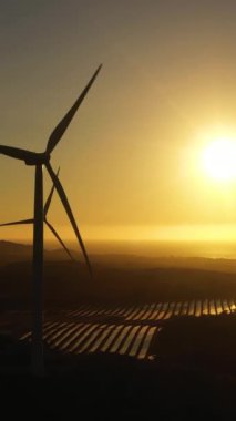 Gün batımında kıyı şeridindeki rüzgar türbinlerinin en üst görüntüsü. Rüzgar santrali. Filipinler.