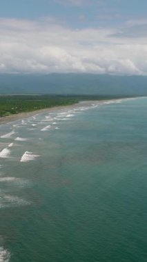 Filipinler 'de sörf yapmak için ünlü bir yer olan oteller ve turistlerle dolu bir sahil insansız hava aracı. Sabang Sahili, Baler, Aurora, Filipinler.
