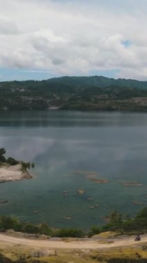 Mining quarry with flooded bottom. Lake with blue water near sand pit. Sipalay, Negros, Philippines.