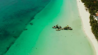 Boracay 'ın Beyaz Sahili ve insanlar Grotto Willys Kayası' nın yakınındaki turkuaz maviş denizinde yüzerler ve üzerinde Bakire Meryem Heykeli bulunur. Uzayı metin için kopyala. Yaz ve seyahat tatil konsepti.