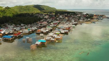 Balıkçı köyünde deniz kenarında duran eski ahşap ev, hava manzaralı. Dapa, Siargao, Filipinler.