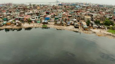 Mahalle sakinlerinin yaşadığı gecekondu mahalleleri ve nehir kıyısı yukarıdan gelen çöplerle doluydu. Manila, Filipinler.