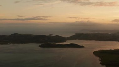 Tropikal adalarla deniz yüzeyinde günbatımı, üst manzara. Su yüzeyine yansıyan güneş. Okyanusun üzerinde gün batımı. Deniz Burnu, Yaz ve Seyahat Tatil Konsepti. Siargao, Filipinler