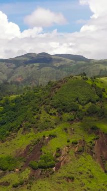 Yeşil tepelerin ve dağların hava aracı mavi gökyüzü ve bulutların arka planına karşı. Sri Lanka.