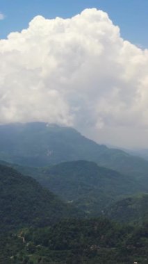 Mountains covered rainforest, trees and blue sky with clouds. Sri Lanka.