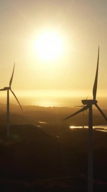 Rüzgar türbinlerinin hava aracı günbatımında deniz kıyısında elektrik üretimi için. Rüzgar santrali. Ekolojik manzara. Filipinler.