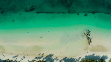 Turistlerle dolu beyaz kumlu plaj ve göl mavisi su, yazı için yer kopyalama, üst manzara. Dalgalı ve tropik plajlı bir okyanus. Yaz ve seyahat tatil konsepti