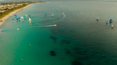 Boracay adasında turistler ve yelkenli yatlar ile beyaz plaj gün batımı nda, üst görünümü. Yelkenli tekne ile tropikal beyaz plaj. Yaz ve seyahat tatili konsepti.