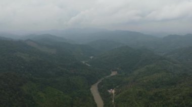 Tepeler ve yağmur ormanları ile dağların arasındaki nehrin havadan görünüşü. Sumatra, Endonezya.