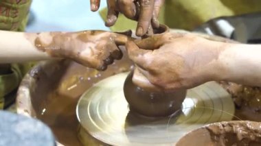 Çocukların elleri kil kalıbı yapar. Çömlekçi çarklı çömlek atölyesi.