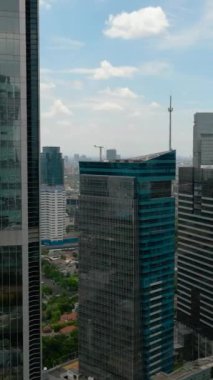 Jakarta şehir merkezindeki ofis binaları ve gökdelenler yukarıdan görünüyor. Dikey video.