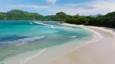 Okyanus sörfü ve dalgalarıyla geniş kumlu bir sahil. Seyşeller, Mahe. Baie Lazare Plajı.