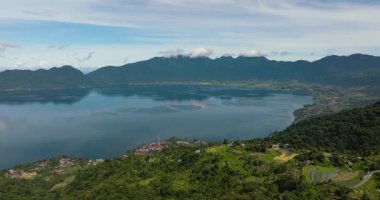 Güzel mavi Maninjau Gölü 'nün ve volkan kraterinin içindeki tarım arazisinin insansız hava aracı. Sumatra, Endonezya.
