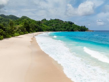 Altın kumlar bu cennet plajında turkuaz dalgalarla karşılaşıyor. Seyşeller. Anse Niyet Sahili.