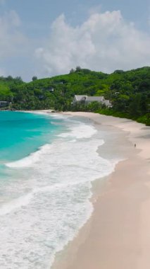 Bu plaj, körfezin masmavi sularına hafifçe eğimli yumuşak bej kumlara sahiptir. Seyşeller, Mahe. Anse Niyet Sahili.