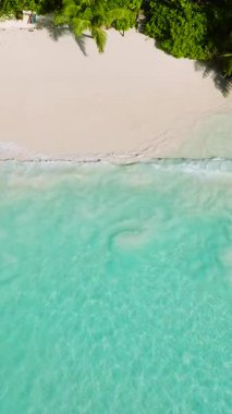 Turkuaz su, kayaların oluşturduğu ıssız bir kumsalla buluşur. Seyşeller, Mahe. Küçük Anse.