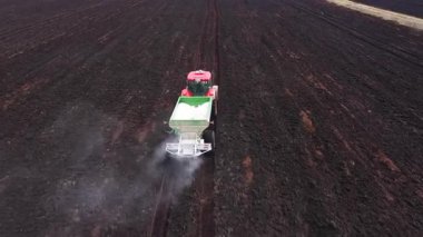Traktörün hava görüntüsü kuru gübreleri yayar. Mevsimlik filizlenme ve mahsul veriminde artış.