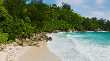 Turkuaz okyanusun yumuşak sörfü kumlu sahille buluşur. Seyşeller, Mahe. Anse Niyet Sahili.