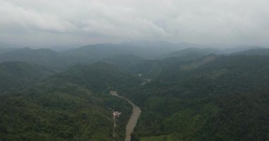 Dağların ve tepelerin arasında yağmur ormanlarıyla birlikte nehrin insansız hava aracı. Sumatra, Endonezya.