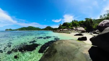Su altı kayaları, büyük granit kayalar ve tropikal bitki örtüsü olan turkuaz bir göl. Seyşeller, Mahe. Baie Lazare.