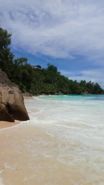 Yoğun tropikal yeşilliklerle çevrili kayalık bir sahil. Turkuvaz suları kumlu kıyıları silip süpürüyor. Seyşeller, Mahe. Anse Niyet.