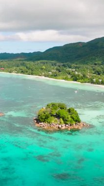 Turkuaz sularda yuva yapmış canlı bir ada, yemyeşil ve kayalık kıyıları var. Praslin, Seyşeller.