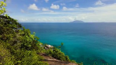 Sakin okyanus ve uzak adaların panoramik manzaralı bir yamaçtaki yemyeşil tropik bitki örtüsü. Seyşeller, Mahe.