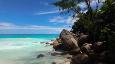 Dev granit kayalar turkuaz su ve bereketli yeşilliklerle çevrili beyaz kumların yanında duruyor. Seyşeller, Praslin. Anse Georgette.