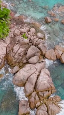 Kocaman granit kayaları, parlak yeşil palmiyelerle kaplı kristal berrak turkuaz sularla çevrili bir ada. St Pierre Adası. Seyşeller.