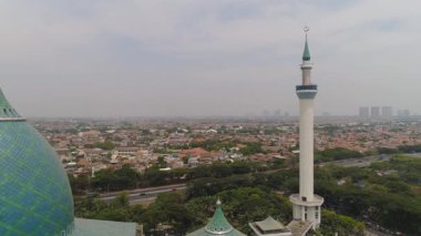 Surabaya otoyoluna, gökdelenlere, binalara ve evlere karşı minare camii Al Ekber. Endonezya 'nın Surabaya kentindeki Al Akbar camii. Java adasında minareleri olan güzel bir cami.
