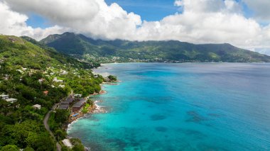 Bereketli yeşil dağlar ve turkuaz denizlerle çevrili tropik bir körfez. Seyşeller, Mahe. Beau Vallon Plajı.