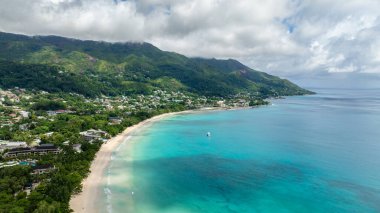 Deniz manzaralı kristal berrak su ile kumlu kıyılar ve yemyeşil tropikal ormanlar buluşuyor. Seyşeller, Mahe. Beau Vallon Plajı.