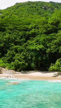 Turkuaz deniz suları ve kayalık sahil şeridini çevreleyen yemyeşil ormanlarla dolu tropikal bir koy. Anse Major. Seyşeller, Mahe.