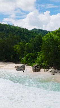 Turkuaz sular, yoğun tropikal bitki örtüsüyle çevrili kumlu bir kıyıya yaklaşıyor. Anse Niyet. Seyşeller, Mahe.