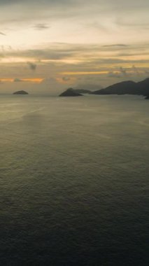 Gün batımı manzaralı sakin bir okyanus manzarası, altın bir ışık, dağınık bulutlar. Seyşeller, Mahe.