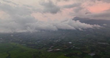 Kayu Aro çay çiftliğinin ve gün batımında Kerinci yanardağının insansız hava aracı. Tropik bölgelerde çay evleri. Sumatra, Endonezya.